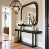 Elegante entrada con espejo y consola de madera oscura.