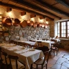 Restaurante rústico con paredes de piedra y utensilios de cobre.